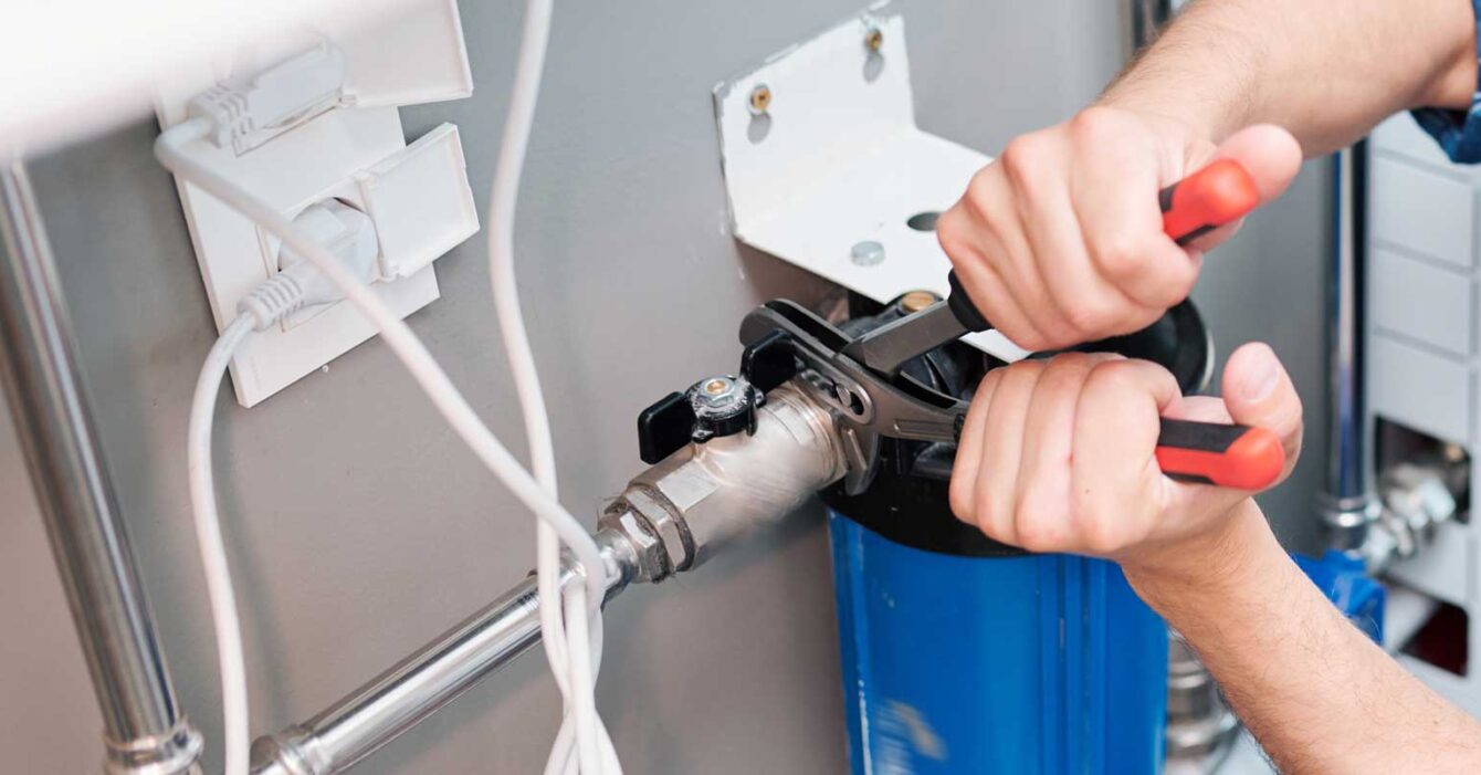 Man-repairing-a-water-softening-and-filtration-system
