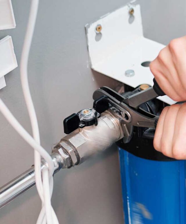 Man-repairing-a-water-softening-and-filtration-system Man-repairing-a-water-softening-and-filtration-system