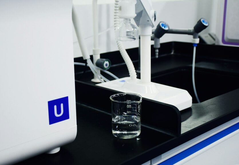 clear glass mug beside white and blue electric toothbrush